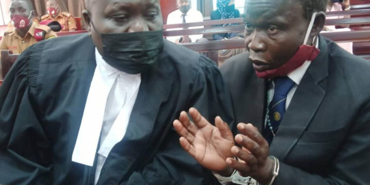 Lawyer Caleb Alaka together with the accused Thomas Kwoyelo. (IMAGE: URN )